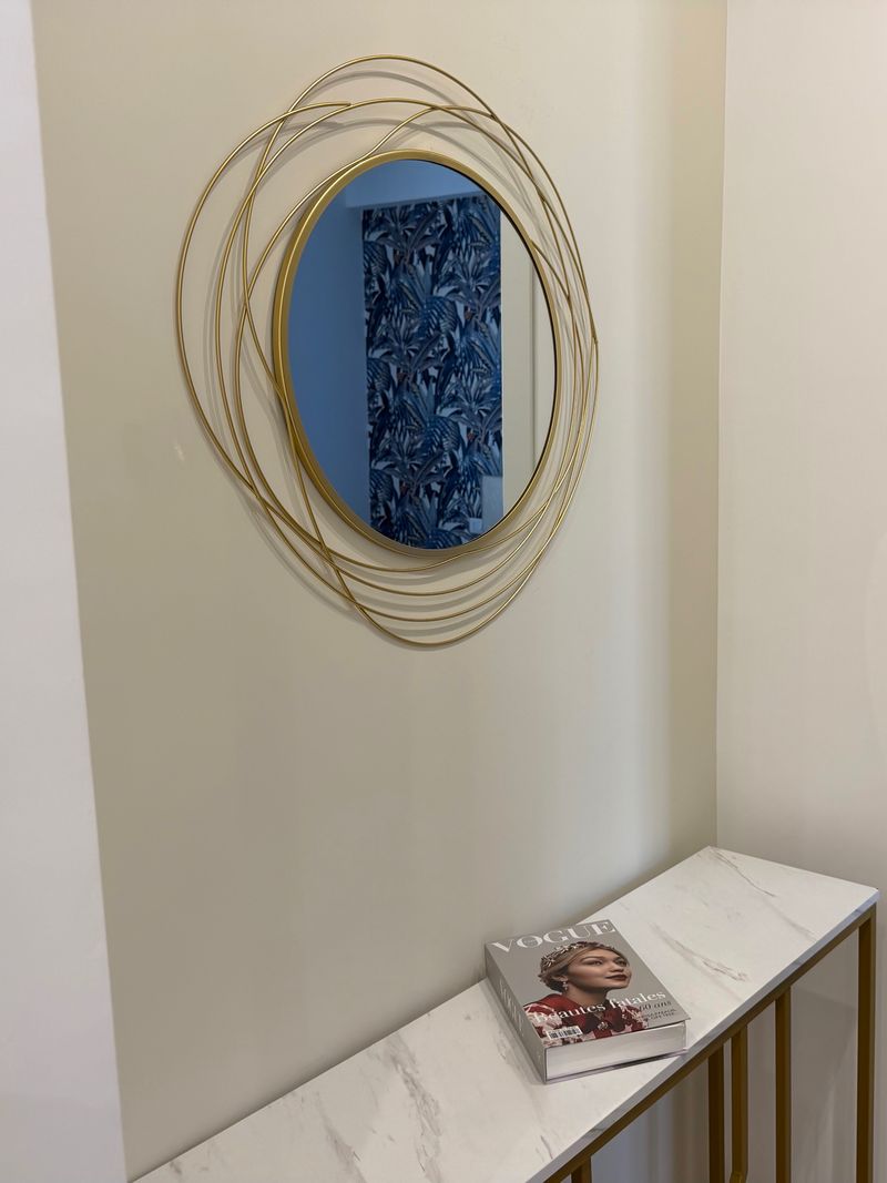 Marble and brass console with the round gold mirror in the hallway