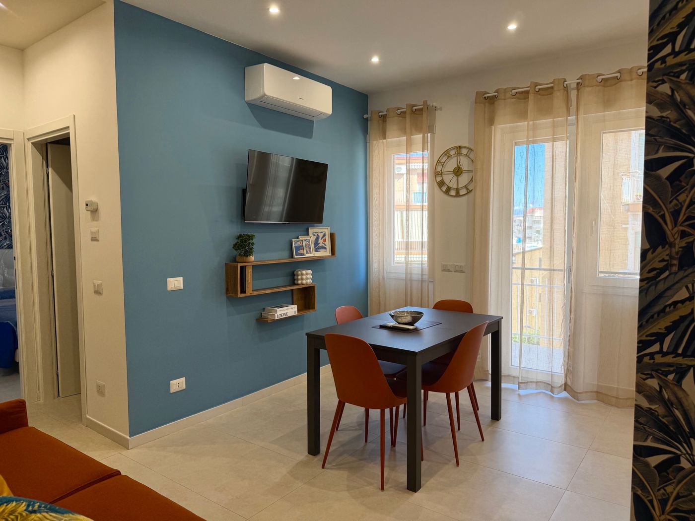 Dining area with a light blue wall, Smart TV and natural light from the window