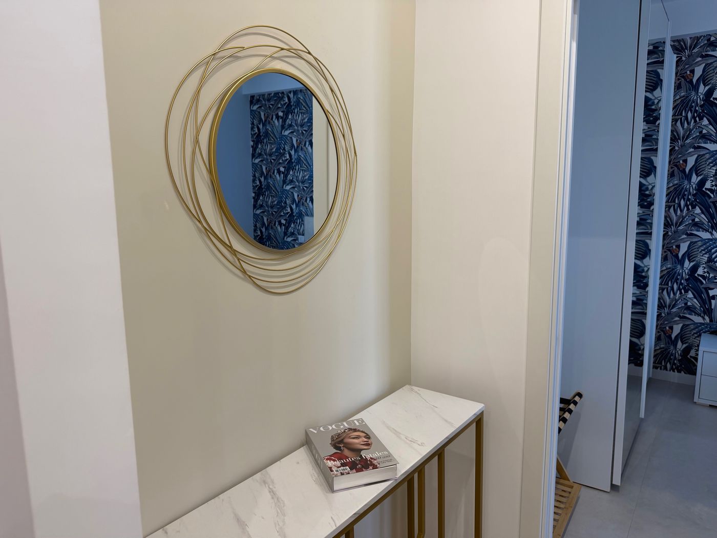 Marble and brass console with the round gold mirror in the hallway