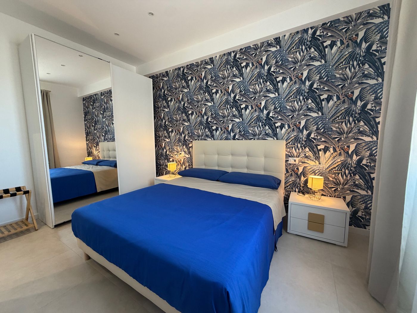 The bedroom seen from the door, with the mirrored wardrobe and lamps on