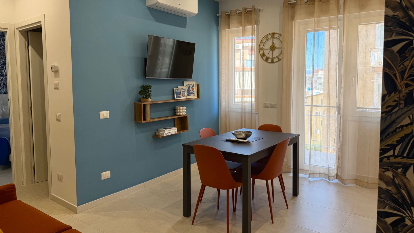 Dining area with a light blue wall, Smart TV and natural light from the window